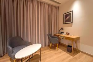 a room with a desk and a chair and a table at Radisson Hotel Nathdwara in Nāthdwāra