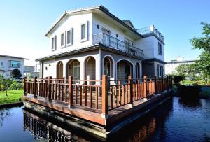 una casa su un fiume con una recinzione in legno di Greenown B&B a Yuanshan