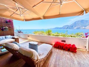 a balcony with wicker chairs and a view of the ocean at Suite Sole Praiano in Praiano