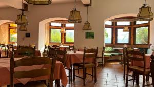 a dining room with tables and chairs and windows at Hotel Garni Vindobona in Pörtschach am Wörthersee