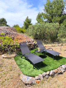 two chairs and a table on a patch of grass at Paradise kosirina in Murter