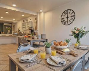 a dining room with a table and a clock on the wall at B&B The Protea in Zonnebeke