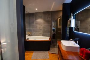 a bathroom with a tub and a sink at Suite Lyséa - Balnéothérapie au Coeur d'Annecy in Annecy