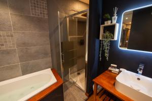 a bathroom with a tub and a sink and a shower at Suite Lyséa - Balnéothérapie au Coeur d'Annecy in Annecy +4 photos