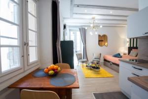 a kitchen and living room with a table with fruit on it at Suite Lyséa - Balnéothérapie au Coeur d'Annecy in Annecy