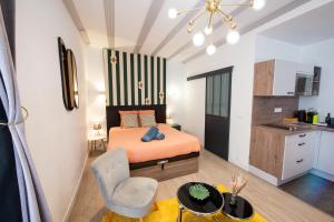 a small bedroom with a bed and a kitchen at Suite Lyséa - Balnéothérapie au Coeur d'Annecy in Annecy