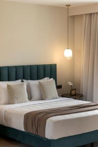 a large bed with a green headboard and white pillows at KANTADA central suite in Argostoli