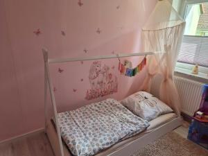 a pink bedroom with a bed with a canopy at Schöne Ferienwohnung nähe Geiseltalsee in Bad Lauchstädt