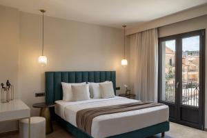 a bedroom with a large bed and a balcony at KANTADA central suite in Argostoli