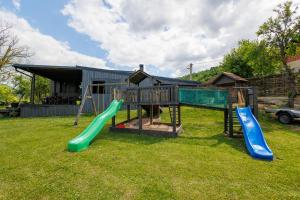 a playground with two slides in a yard at Una Meryland Rooms & Bungalow in Kulen Vakuf