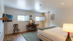 ein Schlafzimmer mit Bett, Schreibtisch und zwei Fenstern in der Unterkunft Villa Alter in Alter do Chão + 42 Fotos