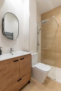 a bathroom with a toilet and a sink and a mirror at Oasis La Corredera, En Pleno Casco Histórico in Córdoba