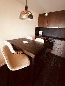 a kitchen with a black table and white chairs at Ludvigsdals Gård in Ystad