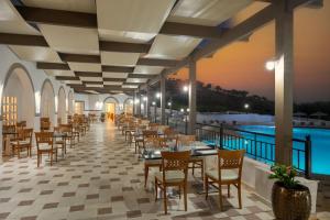 a restaurant with a pool and tables and chairs at Mare Village in Ierapetra +28 photos