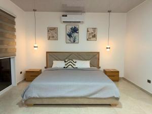 a bedroom with a large bed and two night stands at Suite Rosedelco in Puerto Villamil