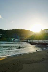 a beach with the sun shining on the water at Terrassi Villa in Angra do Heroísmo