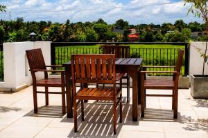 three chairs and a wooden table on a patio at Emerald Edge Villa in Minuwangoda +73 photos