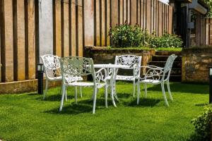 four chairs and a table in the grass at Emerald Edge Villa in Minuwangoda