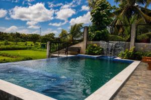 a swimming pool with a bench in a yard at Emerald Edge Villa in Minuwangoda
