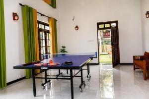 a ping pong table in the middle of a room at Emerald Edge Villa in Minuwangoda