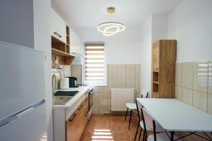 a kitchen with a white counter and a table at Joy Apartament in Nehoiu