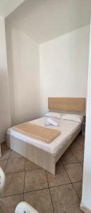 a bed in a room with a white wall at Casa Manzoni in Novara