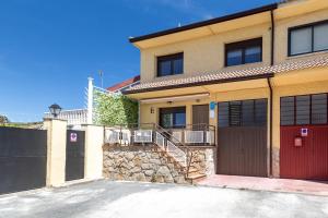 a house with a red door and a garage at Chalet Pinara in El Barraco