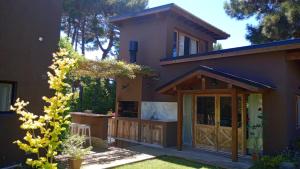 a house with a wooden door and a yard at Alma in Pinamar