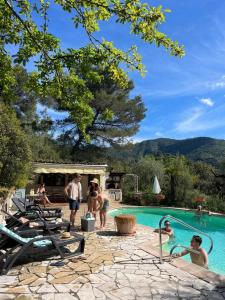 a group of people standing around a swimming pool at Le souffle des montagnes in Levens
