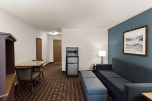 a living room with a couch and a table at Tombstone Grand Hotel, a Baymont by Wyndham in Tombstone