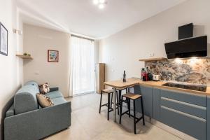 a kitchen with a couch and a table in a room at Casa Amarantia-Appartamento 1 in Noto +8 photos