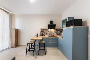 a kitchen with blue cabinets and a counter with stools at Casa Amarantia-Appartamento 1 in Noto