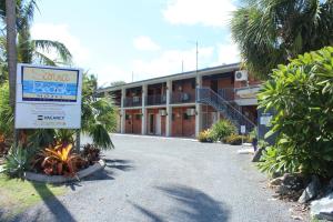 um hotel com uma placa em frente a um edifício em Sarina Beach Motel em Sarina