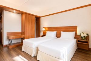 ein Hotelzimmer mit zwei Betten und einem Schreibtisch in der Unterkunft SHG Hotel Bologna in Zola Predosa
