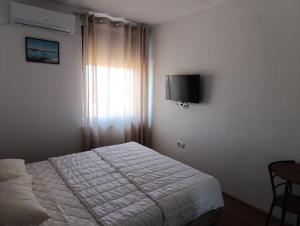 a bedroom with a white bed and a window at Prenociste Gradiska in Bosanska Gradiška