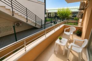 a balcony with two chairs and a table at Limon Pansiyon Burhaniye in Burhaniye