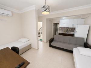 a living room with a couch and a table at Limon Pansiyon Burhaniye in Burhaniye +4 photos