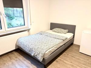 a small bed in a room with a window at Cozy Room Echterdingen Stuttgart Airport & Messe in Leinfelden-Echterdingen +3 photos