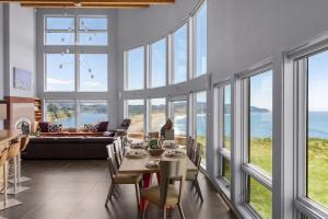 a living room with a table and chairs and windows at Pacific Bliss Haven in Gualala