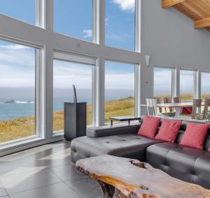 a living room with a couch and large windows at Pacific Bliss Haven in Gualala