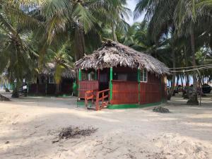 a small hut on a beach with palm trees at Cabañas frente al mar Isla de Guna Yala Aroma in Niatupo +3 photos
