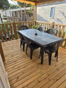 a table and chairs on a wooden deck at Mobilhome, Camping Le Marisol in Torreilles