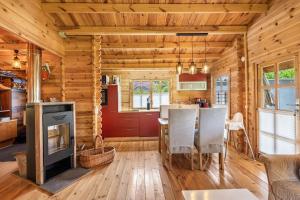 a kitchen and living room with a fireplace in a log cabin at Adler Sommerhaus Oderwitz in  Oderwitz