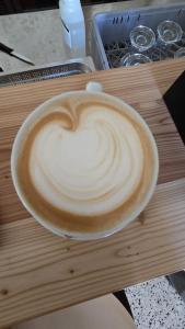 a cup of cappuccino sitting on a wooden table at Vila Soča in Bovec +19 photos