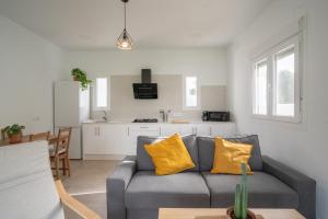 a living room with a gray couch and yellow pillows at La Tertulia in Zahora