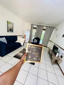 a person holding a sign in a living room at Intsika apartments in Nelspruit