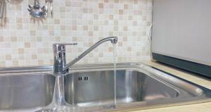 a sink with a faucet in a kitchen at The Light House - Olbia centro in Olbia