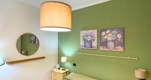 a bathroom with three pictures of flowers on a green wall at The Light House - Olbia centro in Olbia