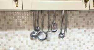 a row of cooking utensils hanging on a wall at The Light House - Olbia centro in Olbia +16 photos