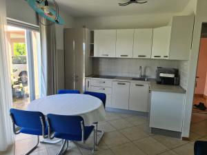 a kitchen with a white table and blue chairs at Alloro in Ankaran +38 photos